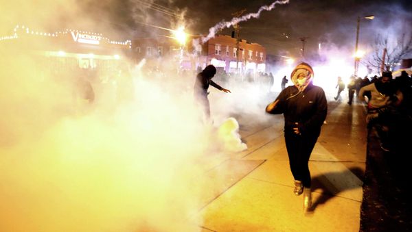 Protesters run from a cloud of tear gas after a grand jury returned no indictment in the shooting of Michael Brown in Ferguson, Missouri, - Sputnik International