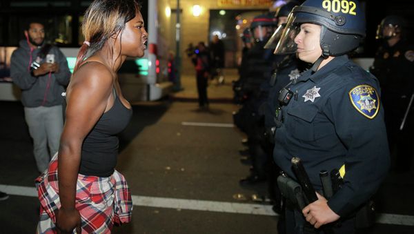 Amanda Ashe of Oakland, left, faces off with a police officer during the second night of demonstrations in Emeryville, California, following the grand jury decision in the shooting of Michael Brown in Ferguson, Missouri Amanda Ashe of Oakland, left, faces off with a police officer during the second night of demonstrations in Emeryville, California, following the grand jury decision in the shooting of Michael Brown in Ferguson, Missouri - Sputnik International