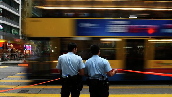 A bus drives past two policemen at the main Nathan Road after normal traffic resumed, at Mongkok shopping district in Hong Kong A bus drives past two policemen at the main Nathan Road after normal traffic resumed, at Mongkok shopping district in Hong Kong - Sputnik International