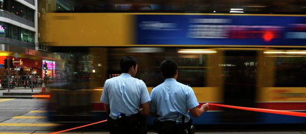 A bus drives past two policemen at the main Nathan Road after normal traffic resumed, at Mongkok shopping district in Hong Kong A bus drives past two policemen at the main Nathan Road after normal traffic resumed, at Mongkok shopping district in Hong Kong - Sputnik International