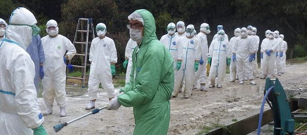 Kumamoto Prefecture, local government workers in white protective overalls line up to be sprayed disinfectant in Taragicho - Sputnik International