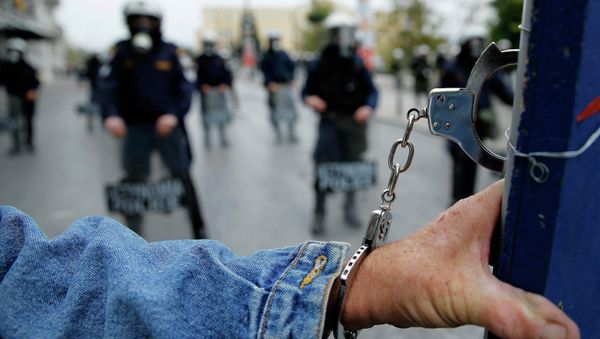 A protester wears handcuffs as he stands in front of riot police following a march during a 24-hour general strike in central Athens November 27, 2014 - Sputnik International