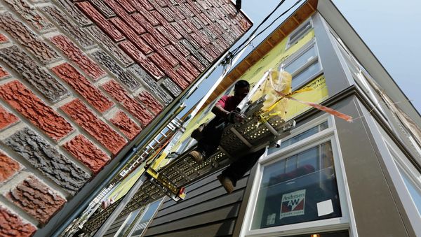 In this Friday, Aug. 17, 2012, file photo, a worker adjusts a scaffold at the site of a new residential construction project in the East Boston neighborhood of Boston - Sputnik International