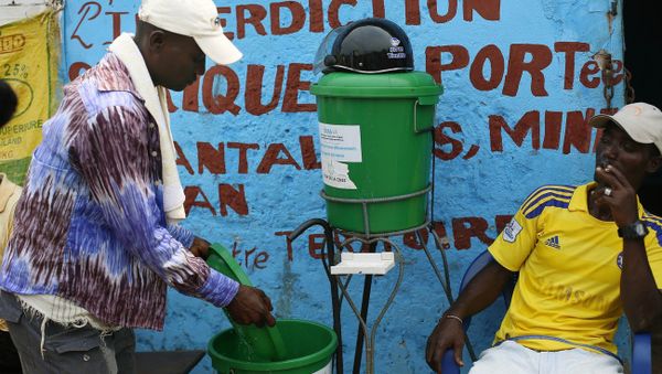 Residents wash their hands with chlorinated water at the fishing port of Conakry, Guinea, Tuesday Nov. 25, 2014 - Sputnik International
