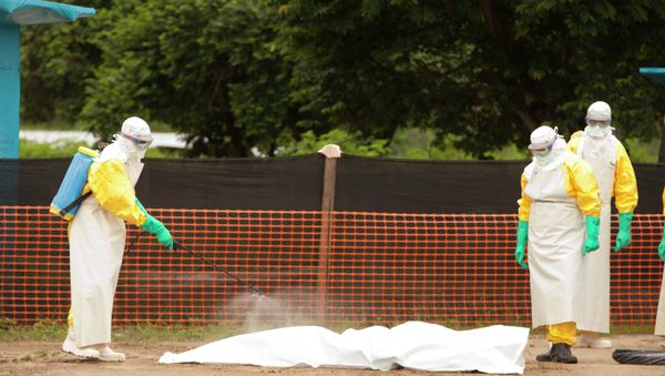 Medical workers are disinfecting the dead body of an Ebola patient. - Sputnik International