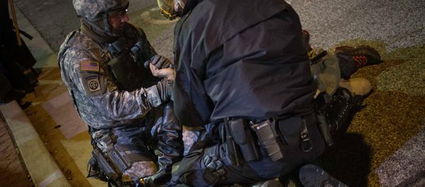 A policeman and member of the National Guard detain a man A policeman and member of the National Guard detain a man - Sputnik International
