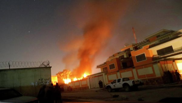 Afghan security forces keep watch while smoke and fire rise from a foreign aid guest house after a Taliban attack in the Afghan capital of Kabul November 29, 2014 - Sputnik International