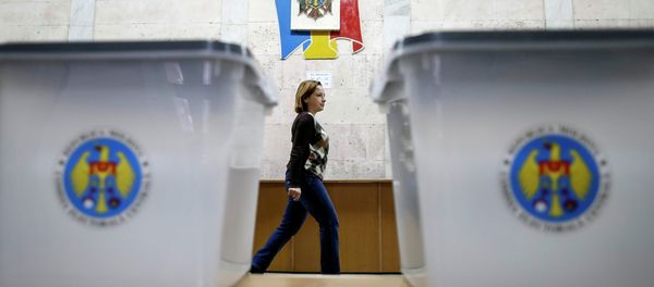 Ballot boxes are seen as a member of a local electoral commission passes by at a polling station in Chisinau November 29, 2014. Ballot boxes are seen as a member of a local electoral commission passes by at a polling station in Chisinau November 29, 2014. - Sputnik International