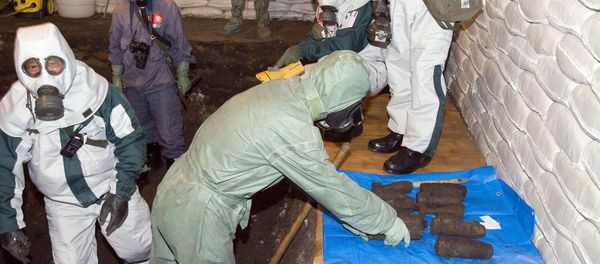 Chinese and Japanese chemical weapons experts in protective clothing dig up abandoned poison gas bombs in a pit in Ning'an, northeastern China's Heilongjiang province - Sputnik International