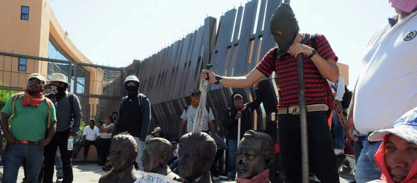 Members of CETEG (State Coordinator of Teachers of Guerrero) prepare to set fire to busts of former Guerrero governors (names listed on poster) outside City Hall during a protest in Chilpancingo, Guerrero December 3, 2014 - Sputnik International