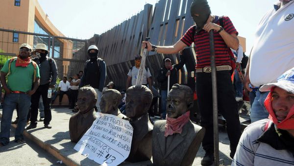 Members of CETEG (State Coordinator of Teachers of Guerrero) prepare to set fire to busts of former Guerrero governors (names listed on poster) outside City Hall during a protest in Chilpancingo, Guerrero December 3, 2014 - Sputnik International