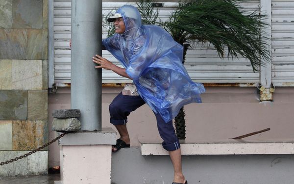 A man holds on to a pole as strong winds blow brought by Typhoon Hagupit in Legazpi, Albay province, eastern Philippines on Sunday, Dec. 7, 2014 A man holds on to a pole as strong winds blow brought by Typhoon Hagupit in Legazpi, Albay province, eastern Philippines on Sunday, Dec. 7, 2014 - Sputnik International