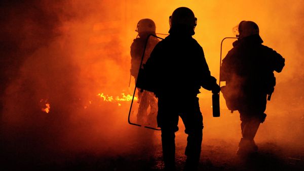 Riot police are seen through a cloud of smoke during clashes with masked youths occupying the Labour Center of Thessaloniki December 6, 2014 - Sputnik International