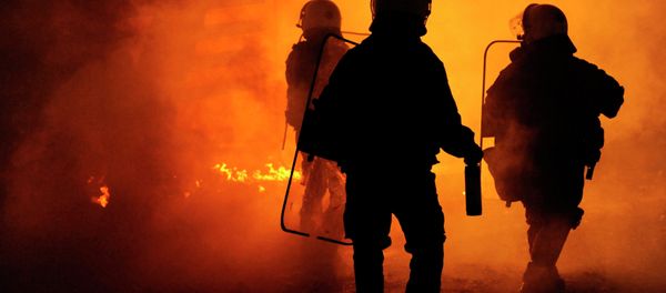 Riot police are seen through a cloud of smoke during clashes with masked youths occupying the Labour Center of Thessaloniki December 6, 2014 Riot police are seen through a cloud of smoke during clashes with masked youths occupying the Labour Center of Thessaloniki December 6, 2014 - Sputnik International