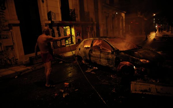 A local resident in his underwear tries to extinguish a burning car used by protesters as a barricade, during riots in Athens neighborhood of Exarchia A local resident in his underwear tries to extinguish a burning car used by protesters as a barricade, during riots in Athens neighborhood of Exarchia - Sputnik International