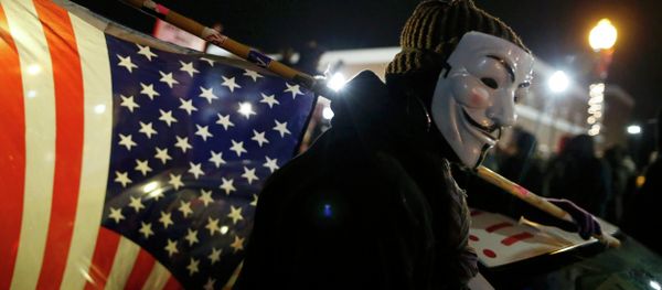 A protester wearing a Guy Fawkes mask carries an American flag outside the Ferguson Police Department in Ferguson, Missouri, November 24, 2014 - Sputnik International