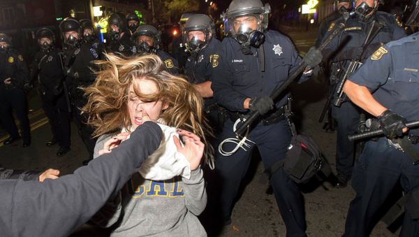 A protester flees as police officers try to disperse a crowd comprised largely of student demonstrators during a protest against police violence in the U.S., in Berkeley, California early December 7, 2014 A protester flees as police officers try to disperse a crowd comprised largely of student demonstrators during a protest against police violence in the U.S., in Berkeley, California early December 7, 2014 - Sputnik International