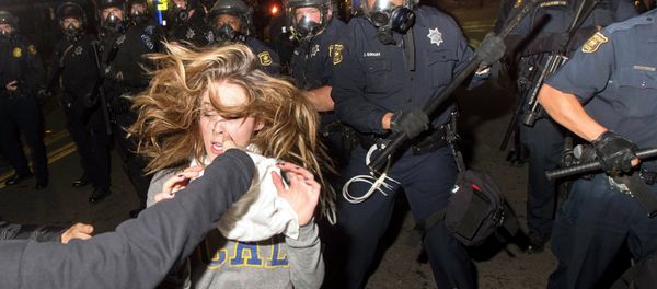 A protester flees as police officers try to disperse a crowd comprised largely of student demonstrators during a protest against police violence in the U.S., in Berkeley, California early December 7, 2014 - Sputnik International