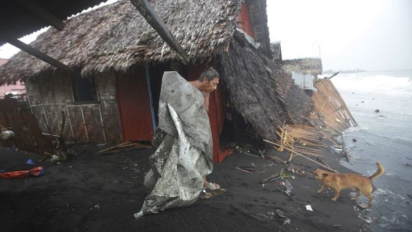 A Filipino man carries a dirty plastic sheet from his house after strong waves from Typhoon Hagupit - Sputnik International