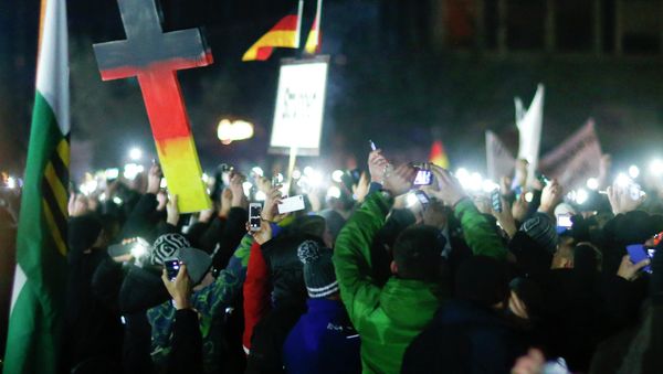 Participants hold up their mobile phones during a demonstration called by anti-immigration group PEGIDA, a German abbreviation for Patriotic Europeans against the Islamization of the West, in Dresden December 8, 2014. Participants hold up their mobile phones during a demonstration called by anti-immigration group PEGIDA, a German abbreviation for Patriotic Europeans against the Islamization of the West, in Dresden December 8, 2014. - Sputnik International