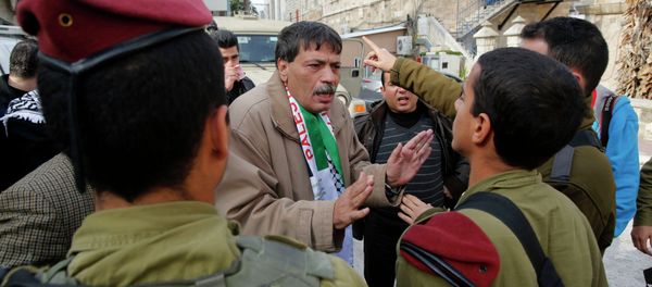 Palestinian Ziad Abu Ein (C), Head of the Anti-wall and Settlement Commission, argues with Israeli soldiers as they prevent him from crossing to Al-Shuhada Street in the West Bank city of Hebron - Sputnik International