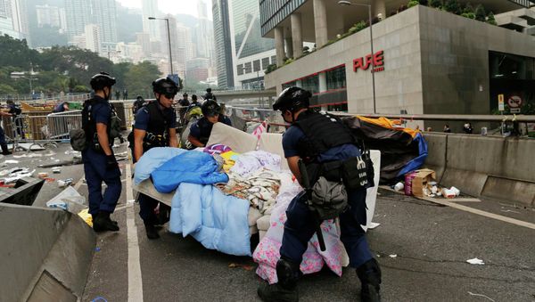 Police remove a sofa as they clear an area previously blocked by pro-democracy protesters near the government headquarters building at the financial Central district in Hong Kong, December 11, 2014 Police remove a sofa as they clear an area previously blocked by pro-democracy protesters near the government headquarters building at the financial Central district in Hong Kong, December 11, 2014 - Sputnik International