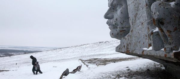 A man and a child walk in the snow at the destroyed war memorial at Savur-Mohyla, a hill east of the city of Donetsk A man and a child walk in the snow at the destroyed war memorial at Savur-Mohyla, a hill east of the city of Donetsk - Sputnik International