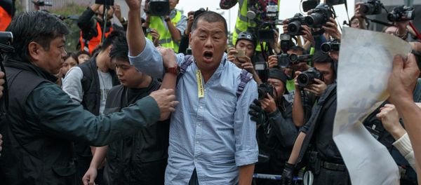 Tycoon and Apple Daily Newspaper owner shouts slogan before he is taken away by police officer at an area previously blocked by pro-democracy supporters, outside the government headquarters in Hong Kong - Sputnik International