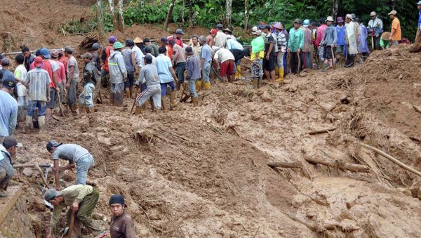 Villagers use shovels to remove mud from the main road at Pasuruhan village in Wonosobo December 12, 2014 - Sputnik International