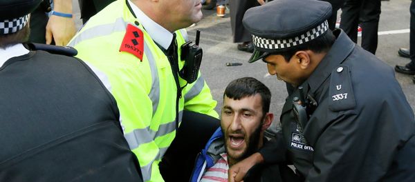 A demonstrator clashes with the police in Parliament Square in London A demonstrator clashes with the police in Parliament Square in London - Sputnik International
