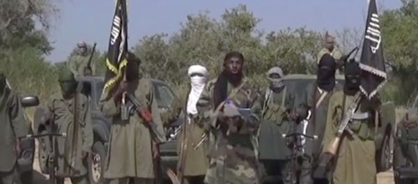 This Friday Oct. 31, 2014 image taken from video by Nigeria's Boko Haram terrorist network, the leader of Nigeria's Islamic extremist group Boko Haram, center, has denied agreeing to any cease-fire with the government and said Friday more than 200 kidnapped schoolgirls all have converted to Islam and been married off. This Friday Oct. 31, 2014 image taken from video by Nigeria's Boko Haram terrorist network, the leader of Nigeria's Islamic extremist group Boko Haram, center, has denied agreeing to any cease-fire with the government and said Friday more than 200 kidnapped schoolgirls all have converted to Islam and been married off. - Sputnik International