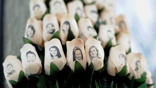 In this Jan. 14, 2013 file photo, white roses with the faces of victims of the Sandy Hook Elementary School shooting are attached to a telephone pole near the school on the one-month anniversary of the shooting that left 26 dead in Newtown, Conn In this Jan. 14, 2013 file photo, white roses with the faces of victims of the Sandy Hook Elementary School shooting are attached to a telephone pole near the school on the one-month anniversary of the shooting that left 26 dead in Newtown, Conn - Sputnik International