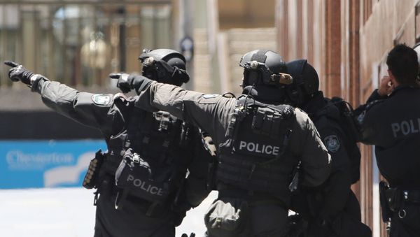Armed police officers point as they stand at the ready close to a cafe under siege at Martin Place in Sydney, Australia, Monday, Dec. 15, 2014 - Sputnik International