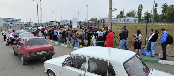 Ukrainian refugees line up to return to their homes in eastern Ukraine at the Russia-Ukraine border - Sputnik International