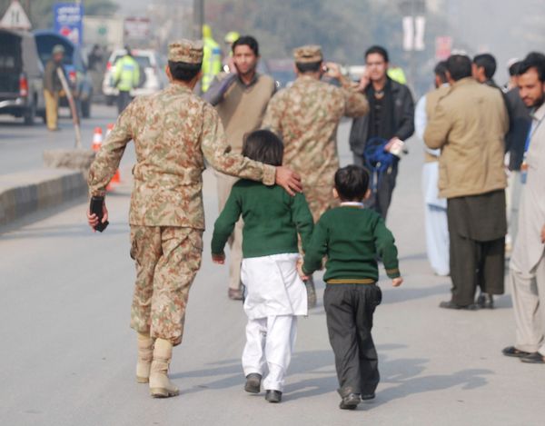 A soldier escorts schoolchildren after they were rescued from the Army Public School that is under attack by Taliban gunmen in Peshawar, December 16, 2014 - Sputnik International
