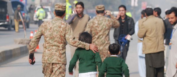A soldier escorts schoolchildren after they were rescued from the Army Public School attacked by Taliban gunmen in Peshawar. A soldier escorts schoolchildren after they were rescued from the Army Public School attacked by Taliban gunmen in Peshawar. - Sputnik International