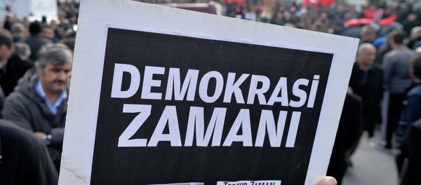 A man holds a placard that reads  a time for democracy  as people gather in support outside Zaman - Sputnik International