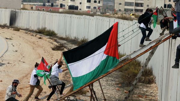 Foreign activists and Palestinian protesters use a metal ramp to cross over a section of the controversial Israeli barrier during a protest over tension in Jerusalem, near the Israeli Qalandia checkpoint between the West Bank city of Ramallah and Jerusalem - Sputnik International