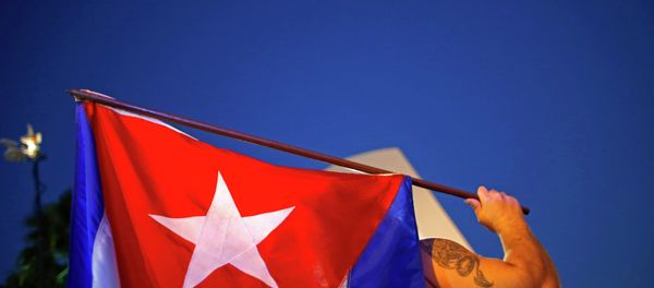 An anti-Castro Cuban exile holds a Cuban flag during a protest after the announcement of restoring diplomatic ties between Cuba and United States, at an area knows as 'Little Havana' in downtown Miami, Florida December 17, 2014. - Sputnik International