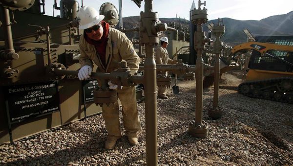 Workers put the final touches on a natural gas well platform owned by Encana south of Parachute, Colorado - Sputnik International