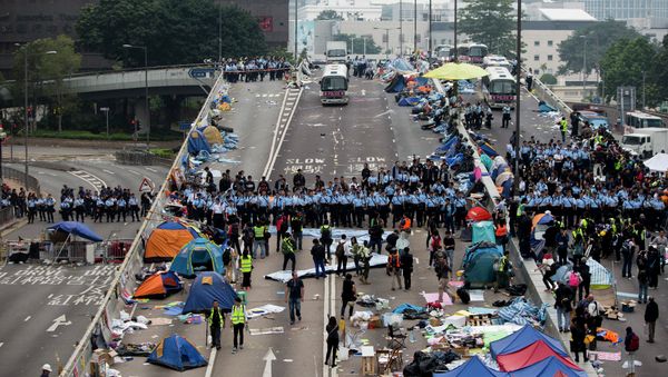 Police officers stand in a line as they prepare to clear tents outside Hong Kong's Government complex in Hong Kong Police officers stand in a line as they prepare to clear tents outside Hong Kong's Government complex in Hong Kong - Sputnik International