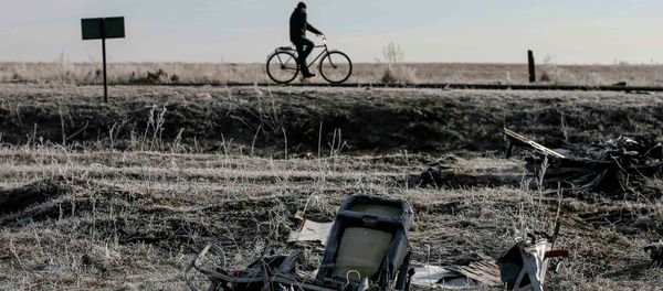 A man rides his bicycle past the wreckage of MH17, a Malaysia Airlines Boeing 777 plane A man rides his bicycle past the wreckage of MH17, a Malaysia Airlines Boeing 777 plane - Sputnik International