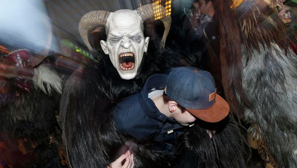 A man dressed as 'Krampus' creature takes part in a parade at Munich's Christmas market - Sputnik International