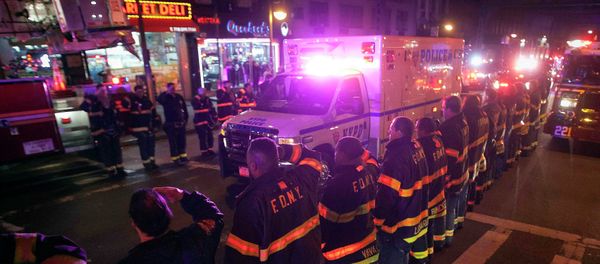 An ambulance carrying one of the two New York Police officers who were shot dead passes by a New York Fire Department honor guard along Broadway in the Brooklyn borough of New York - Sputnik International