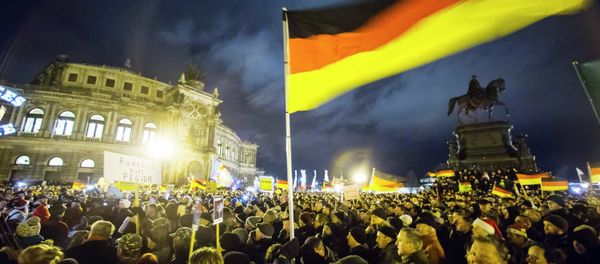 Participants hold German national flags during a demonstration organised by anti-immigration group PEGIDA, a German abbreviation for Patriotic Europeans against the Islamisation of the West, outside Semperoper opera house in Dresden December 22, 2014. - Sputnik International