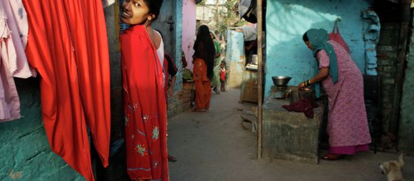 An Indian woman reacts to the camera as another sells meat in a narrow alley at a slum area in New Delhi, India, Tuesday, May 21, 2013 - Sputnik International
