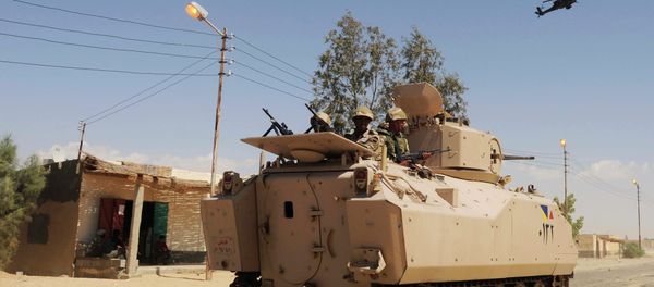 In this Tuesday, May 12, 2013 file photo, Egyptian Army soldiers patrol in an armored vehicle backed by a helicopter gunship during a sweep through villages in in Sheikh Zuweyid, northern Sinai, Egypt - Sputnik International