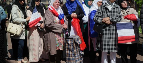 Woman wearing traditional muslim scarf and holding French flags gather outside the town hall in Mantes la Ville, north west of Paris, Friday, May 16, 2014, in protest of the ban of a new mosque Woman wearing traditional muslim scarf and holding French flags gather outside the town hall in Mantes la Ville, north west of Paris, Friday, May 16, 2014, in protest of the ban of a new mosque - Sputnik International