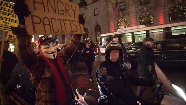 A demonstrator wearing a Guy Fawkes mask walks up 6th Ave as he protests against the police in the Manhattan borough of New York December 23, 2014 A demonstrator wearing a Guy Fawkes mask walks up 6th Ave as he protests against the police in the Manhattan borough of New York December 23, 2014 - Sputnik International