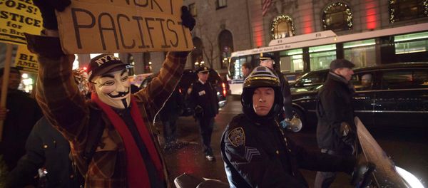 A demonstrator wearing a Guy Fawkes mask walks up 6th Ave as he protests against the police in the Manhattan borough of New York December 23, 2014 A demonstrator wearing a Guy Fawkes mask walks up 6th Ave as he protests against the police in the Manhattan borough of New York December 23, 2014 - Sputnik International